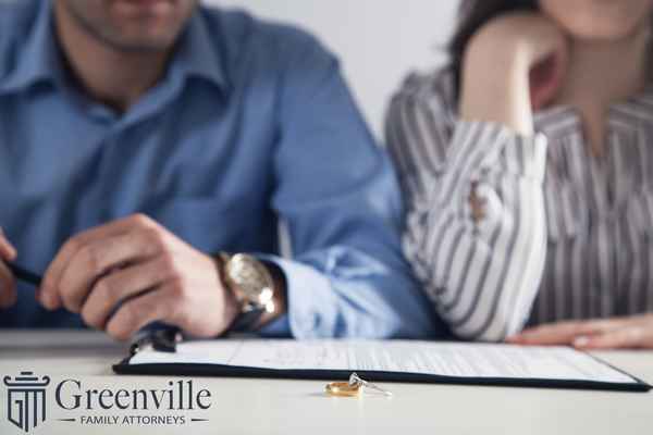 couple signing divorce papers, leading causes of divorce